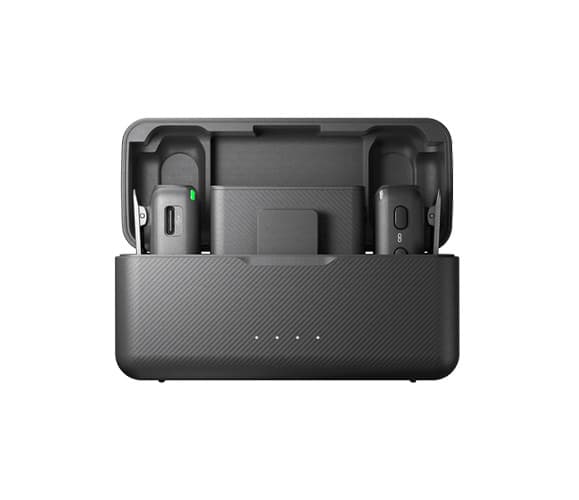 A close up of the lav mic: DJI Mic 2 in it's charging case against a white background.